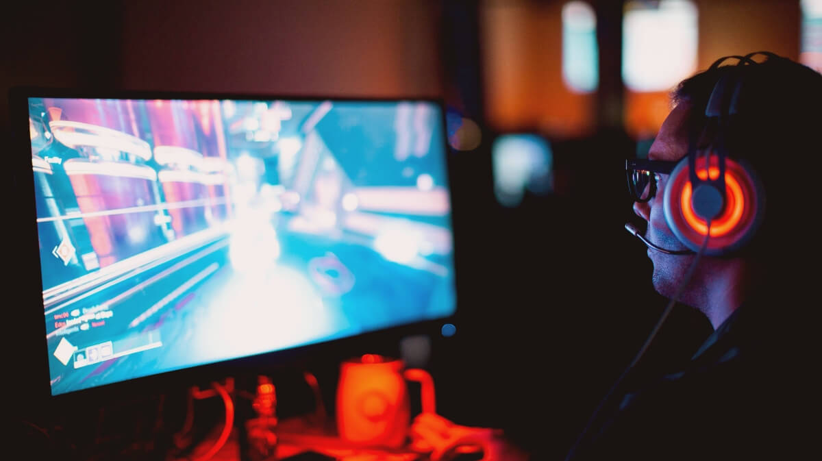 homem de fone jogando no computador