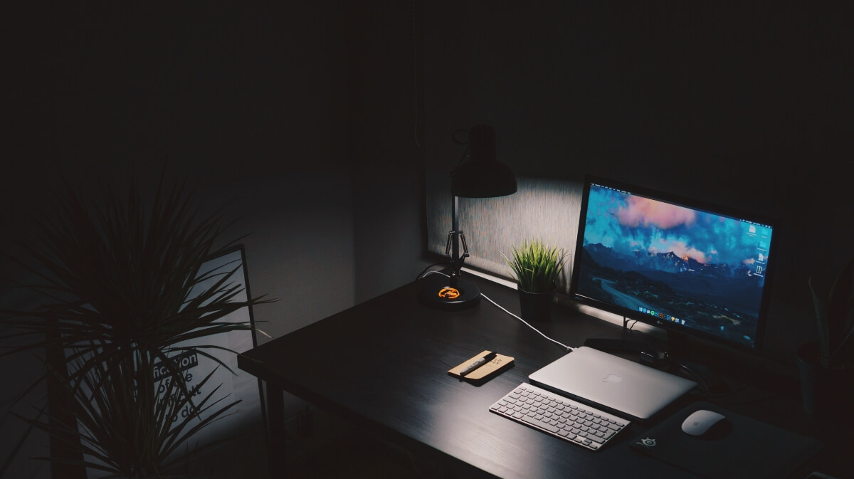 sala escura com computador abajur