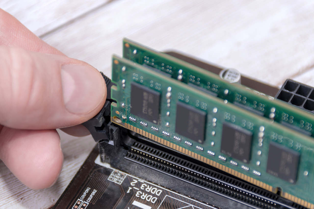 Pessoa mexendo em uma memória RAM de computador gamer